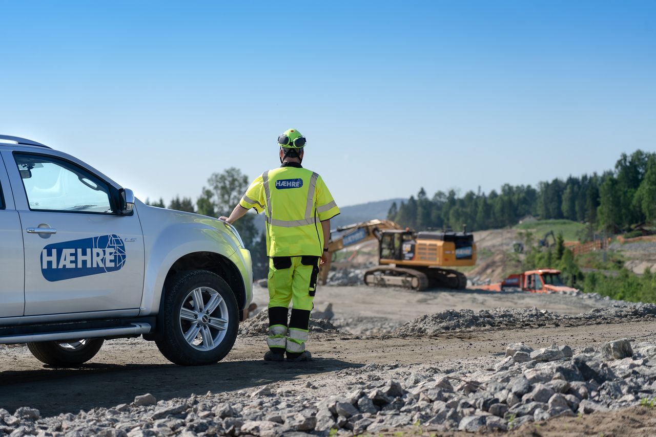 Hæhre-ansatt ved pickup-bil ser utover anleggsområde ved Minnesund
